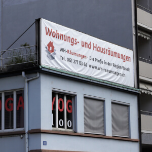 Gebäude von WH-Räumungen in Basel mit Werbeblache für Wohnungs- und Hausräumungen – zuverlässiger Partner für Nachlassräumung und Antiquitäten Ankauf in der Schweiz.